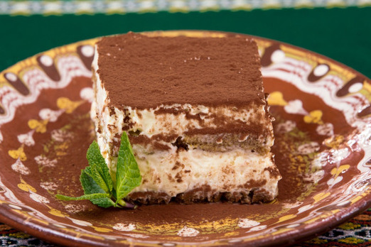 Hausgemachtes Tiramisu mit Kakao und Creme auf einem Teller serviert