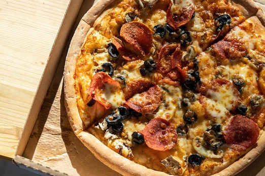 Frisch gebackene Pizza mit knusprigem Rand von La Cantina Hallein zur Lieferung